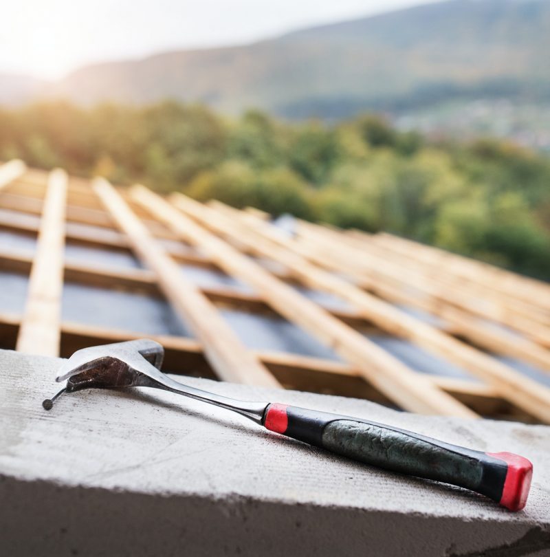 Hammer on the roof on the construction site.