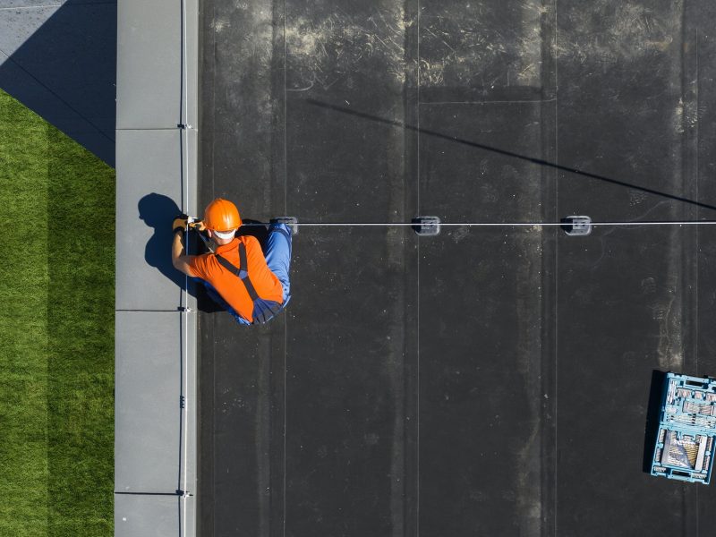 Technician Installing Lightning Protection Rod on Top of Building